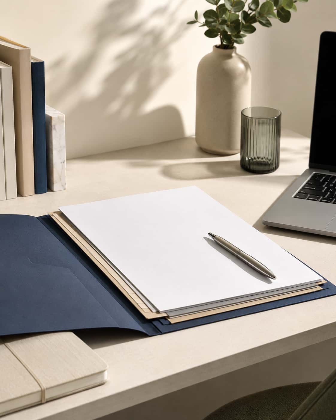 Geordnete Dokumente, Laptop und Stift als ruhiges Symbol für Impressum und rechtliche Angaben
